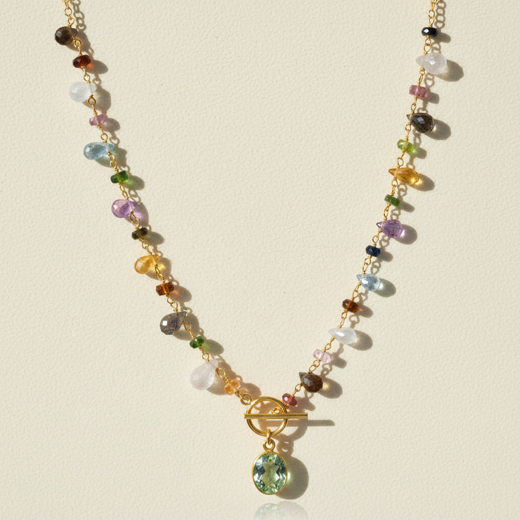 Gold-tone toggle necklace with multicolor beads and green oval pendant charm