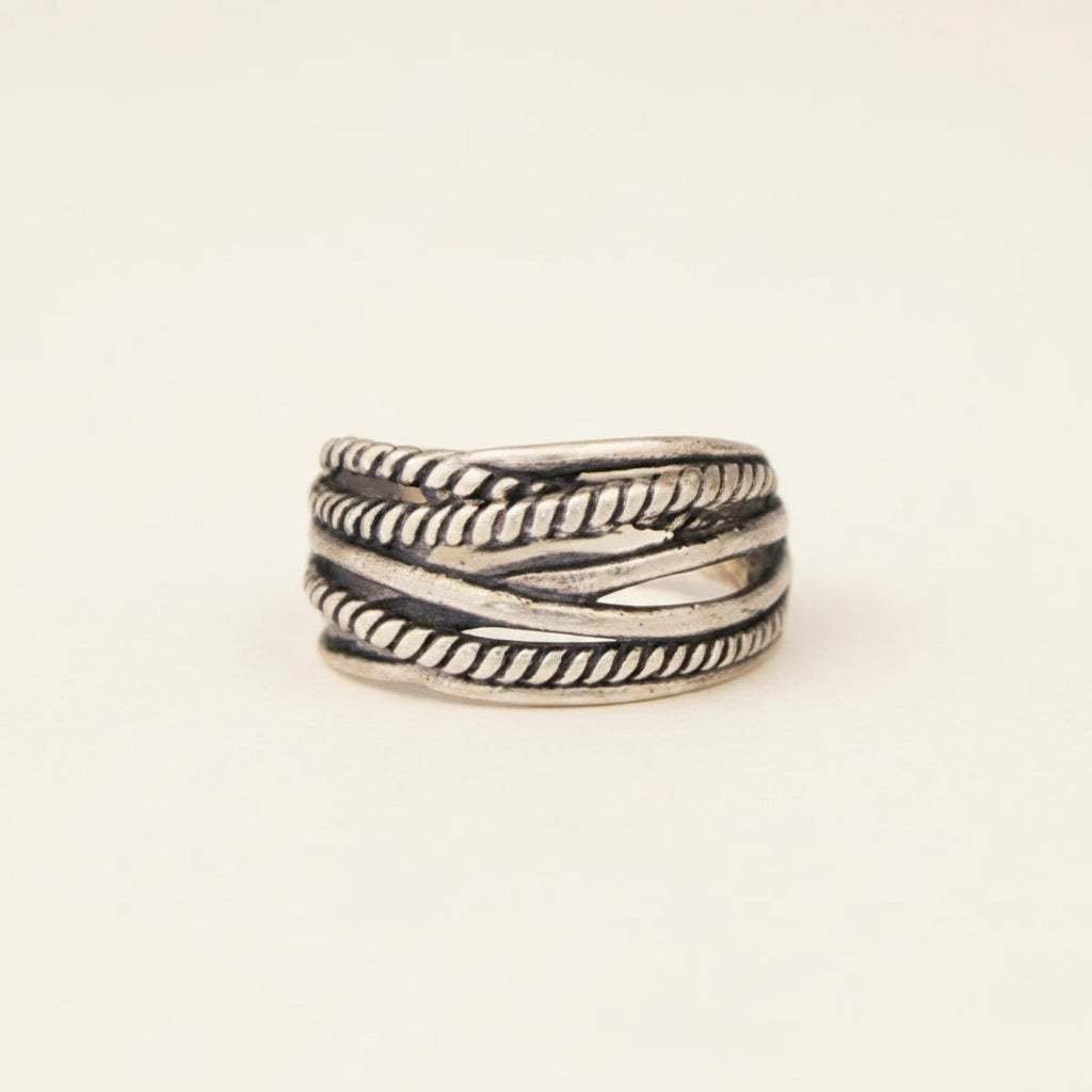 Silver ring with braided design on a white background