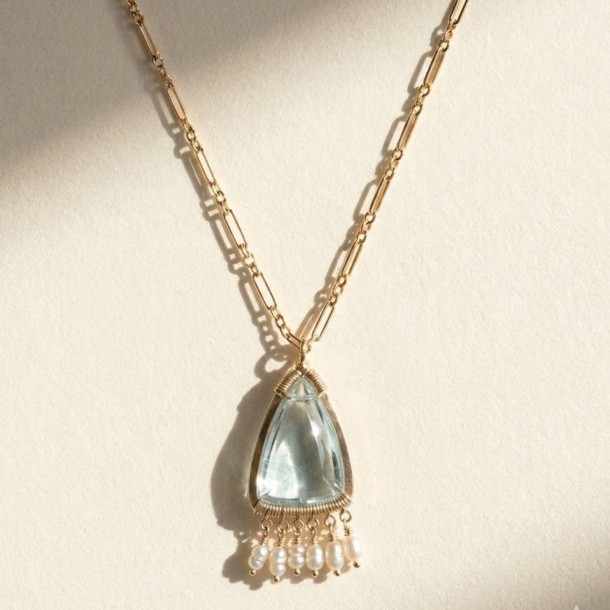 Gold-tone chain necklace with aqua teardrop pendant and pearl bead fringe