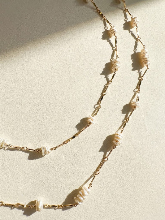 Long gold-tone chain necklace with keshi pearls and leaf-like shell drops