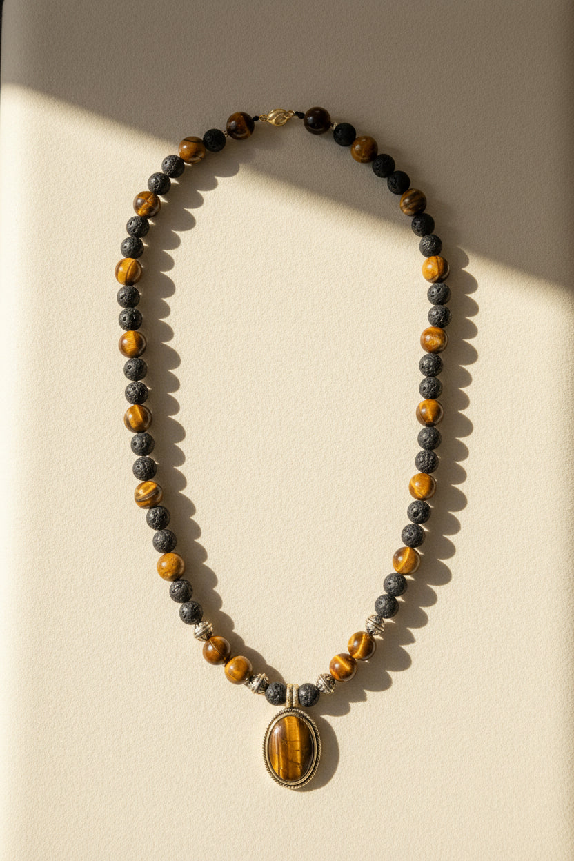 Ember & Ash beaded necklace with dark beads, amber accents, and gold oval pendant
