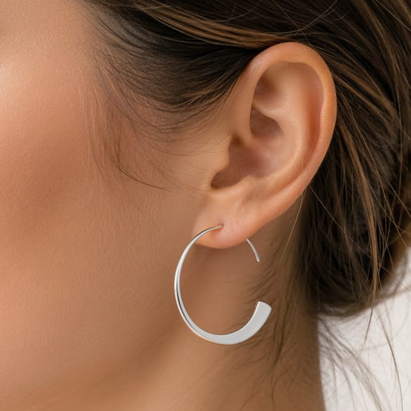 Tapered silver hoop earring on model ear, oval hoop with flat taper