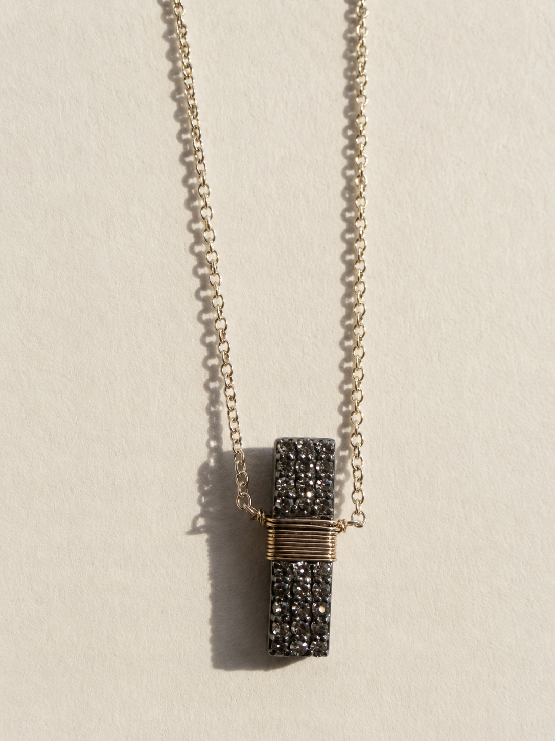 Pavé diamond bar necklace with gold chain and wrapped rectangular pendant