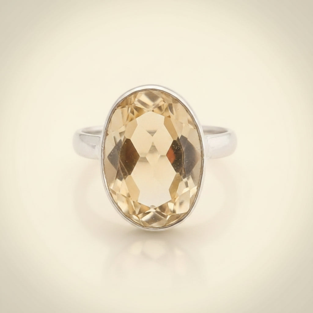 Ring with a large faceted yellow gemstone on a white background