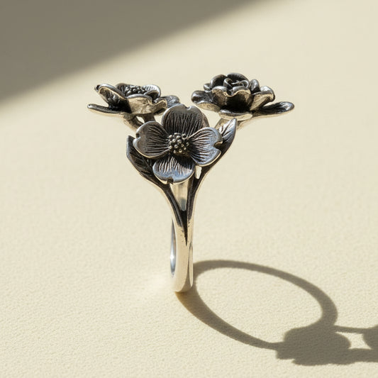 Silver dogwood flower ring with three blossoms on curved band, side view
