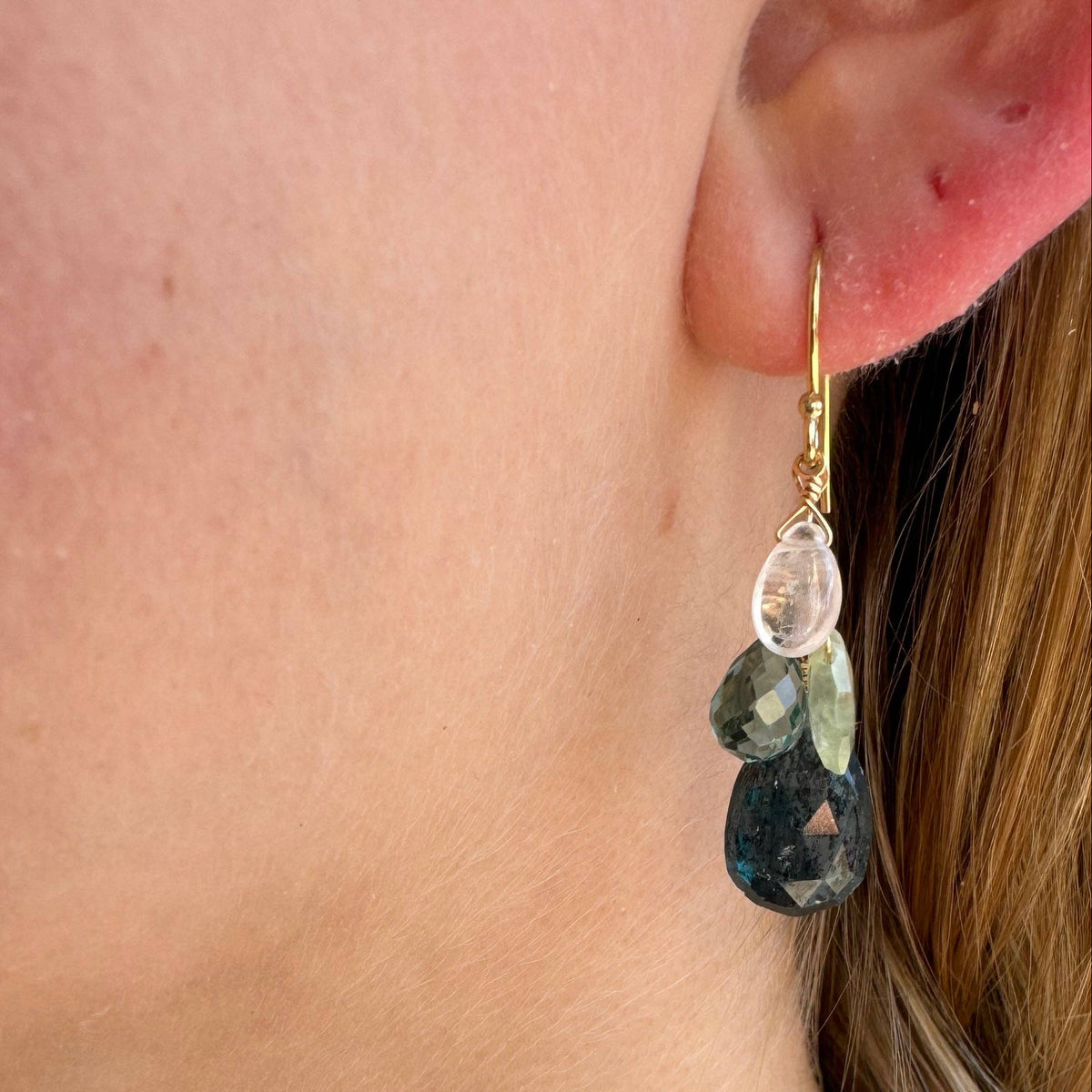 Gold hoop drop earrings with faceted clear and green beads and dark blue teardrop