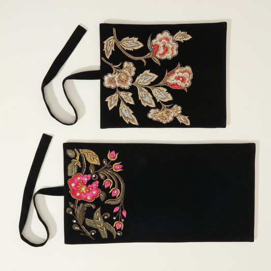 Black embroidered jewelry roll with gold, red, and pink floral beadwork