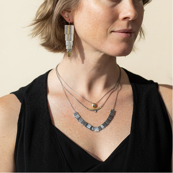 Side view of silver-gray and gold dangling rectangle earrings