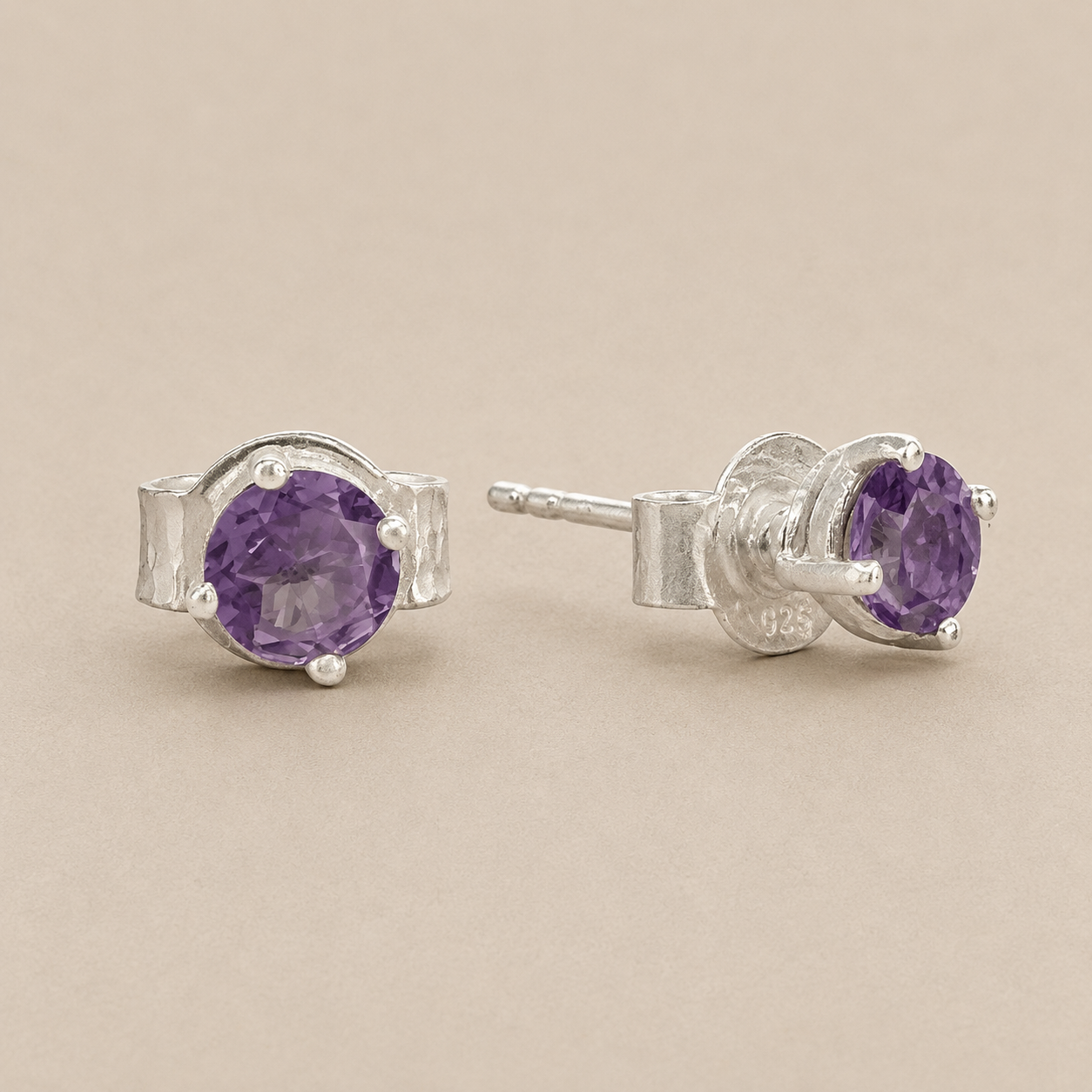 Silver prong-set amethyst stud earrings with purple oval gemstone and butterfly back