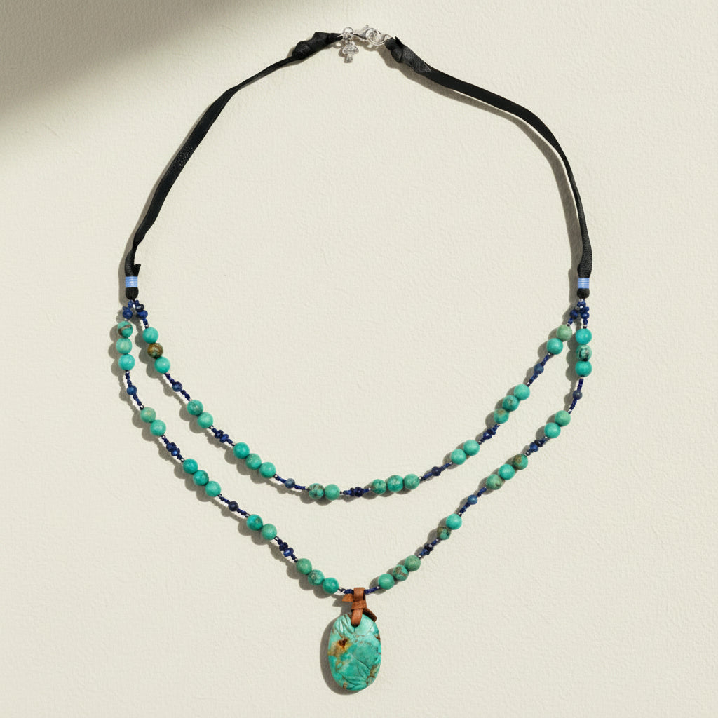 Necklace with turquoise beads and a pendant on a white background