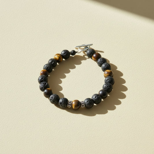 Beaded talisman bracelet with dark stone beads, brown-gold accents, and silver clasp