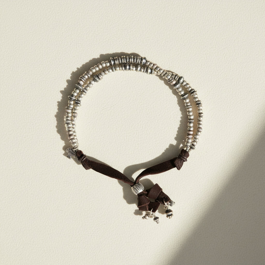 Necklace with silver beads and black ribbon on a white background
