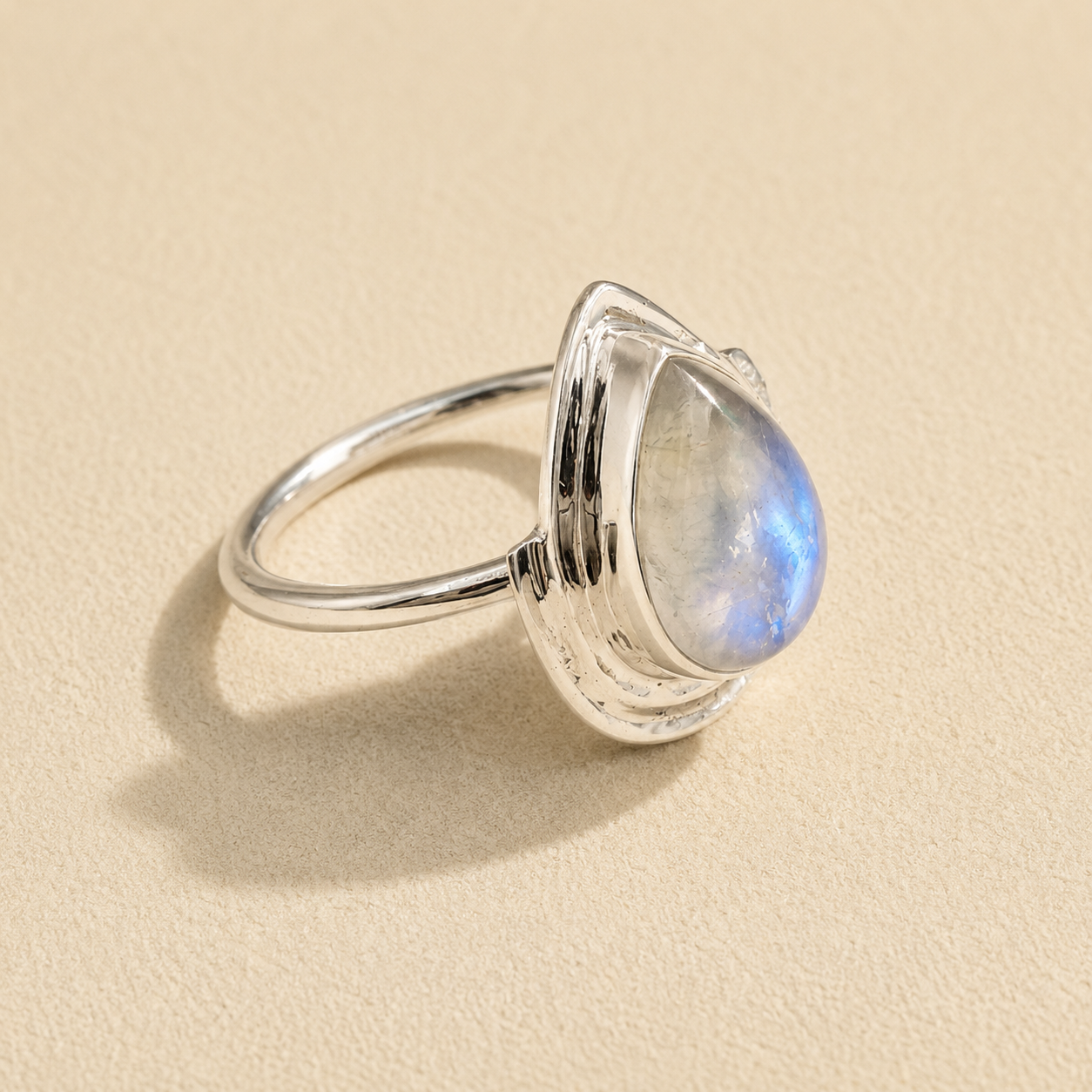 Silver teardrop moonstone ring showing blue glow on teardrop stone and slim band