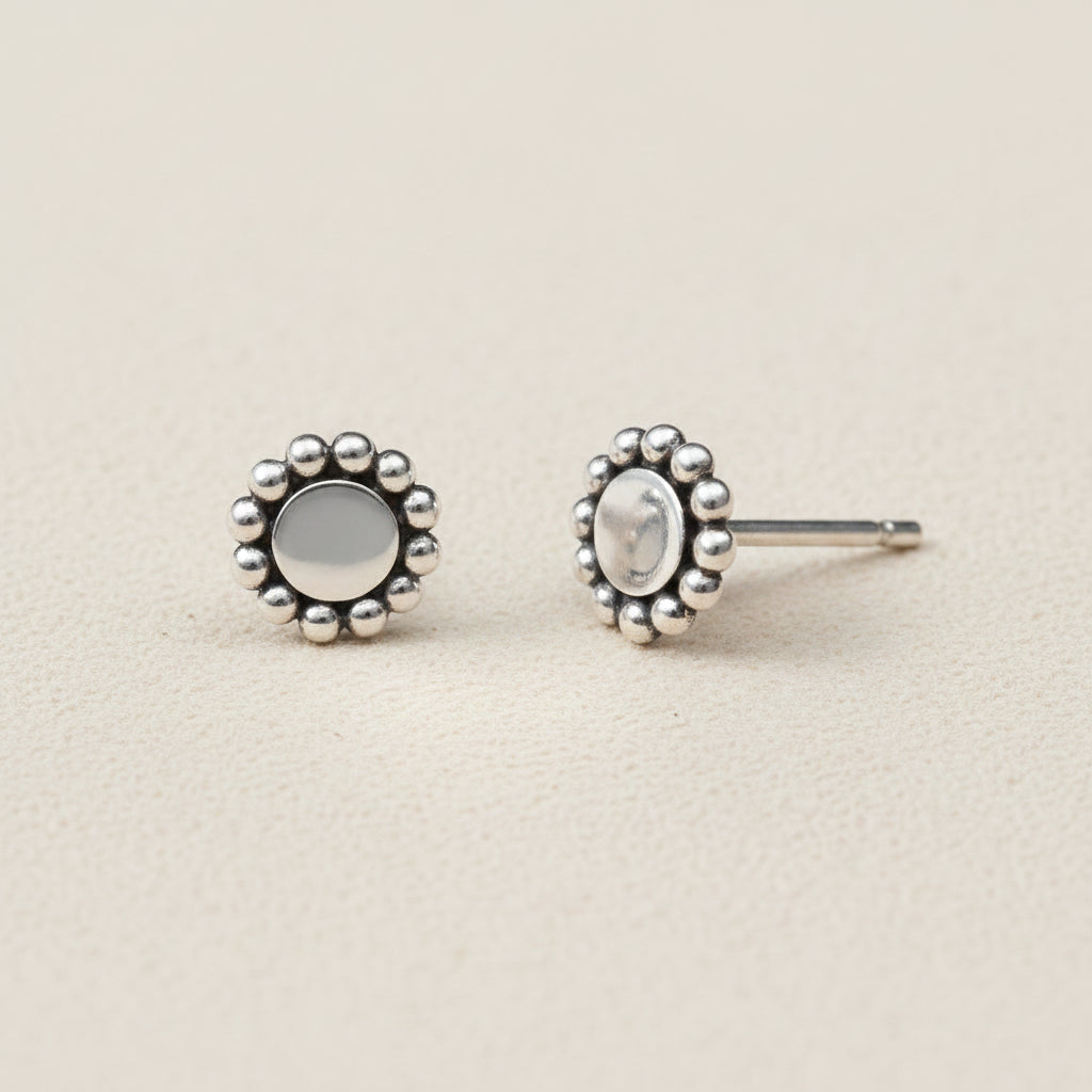Silver earrings with floral designs on a white background