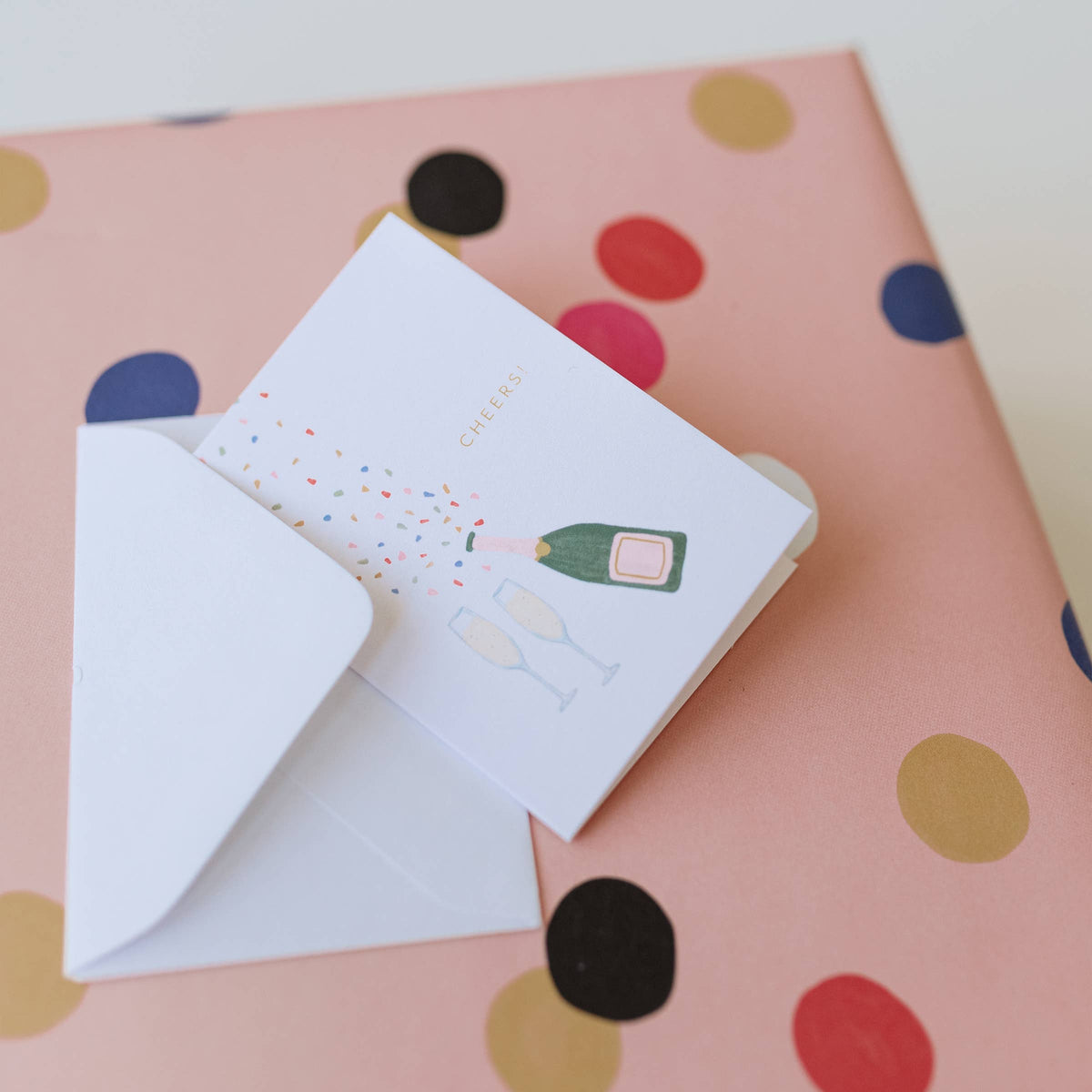 Mini greeting card with champagne bottle graphic and confetti detail