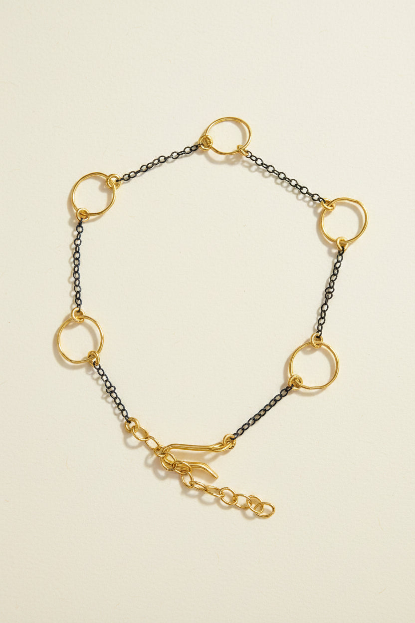 Two-tone link bracelet with small circular charms and gold rings