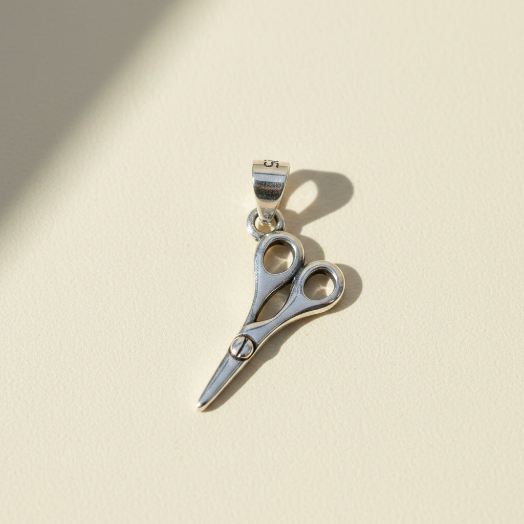 Scissors-style pendant with circular accents and small trim bail