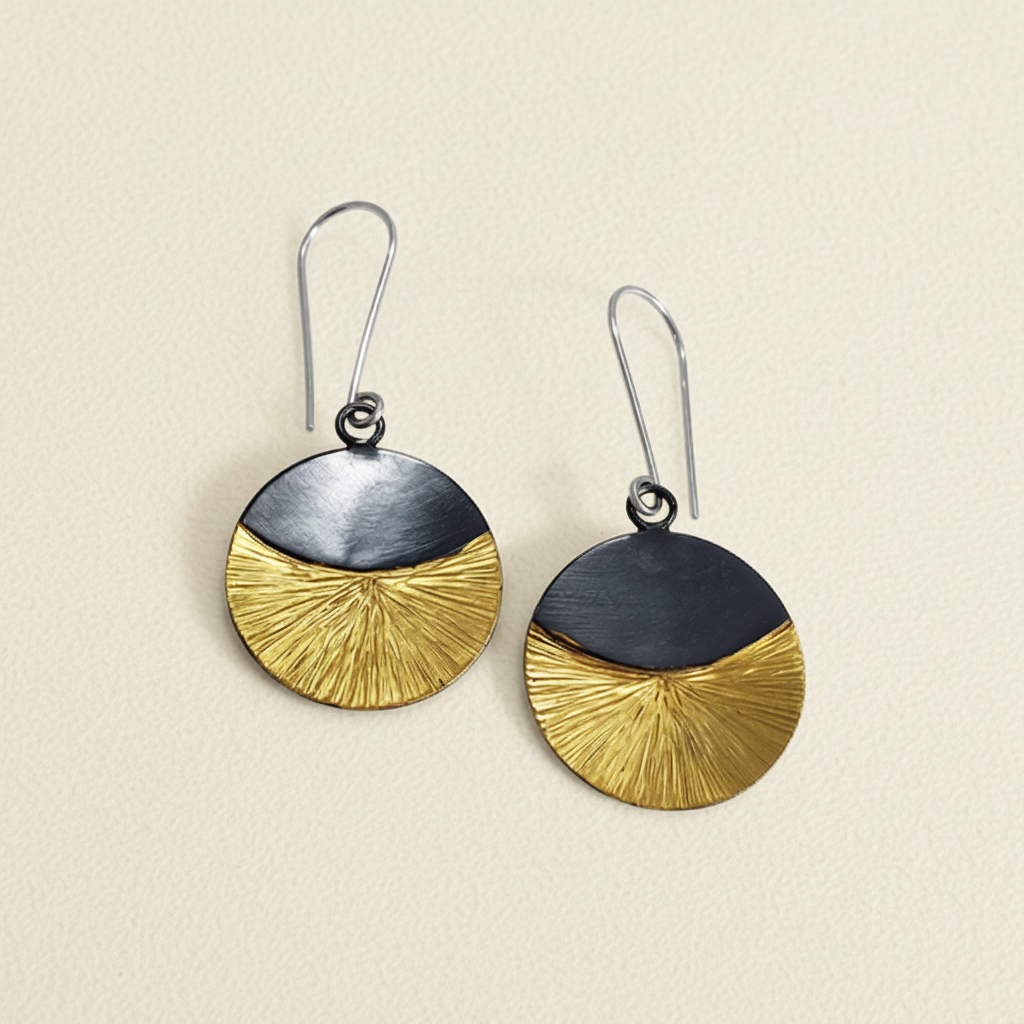 Pair of earrings with gold and silver circular designs on a white background