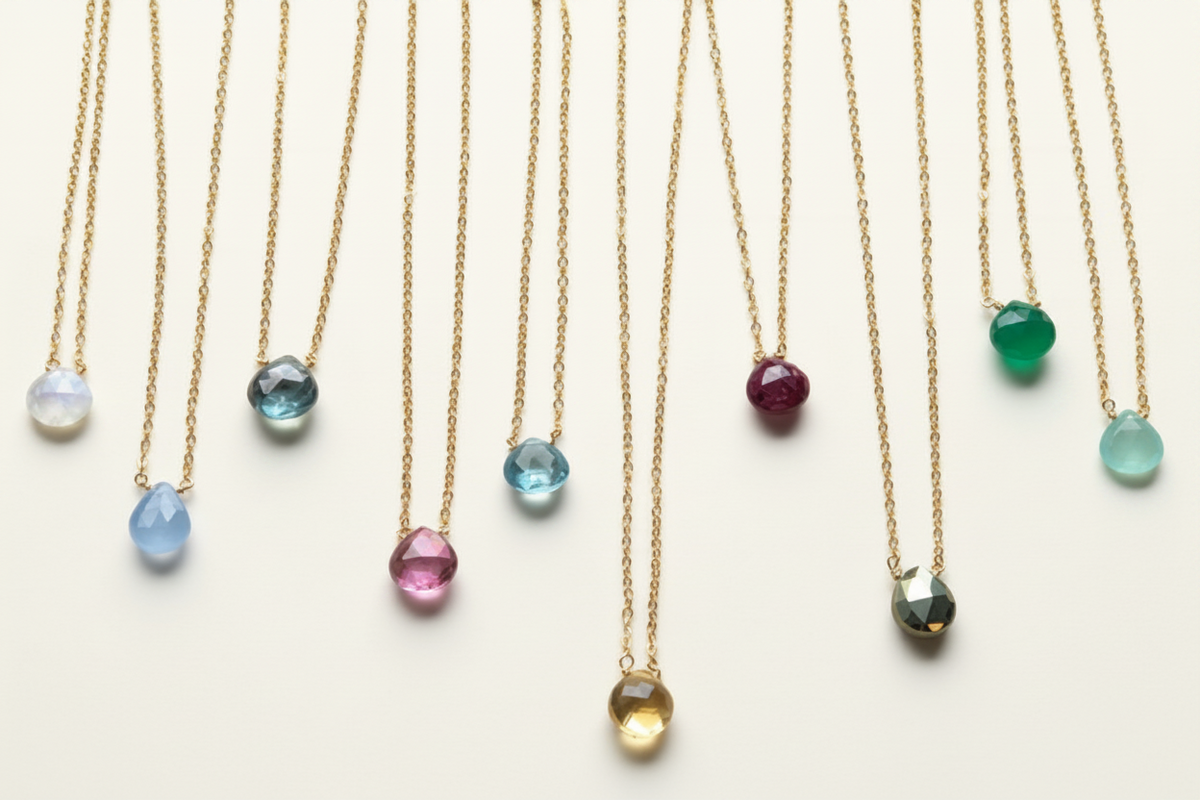 Dainty gold-tone chain necklace with faceted teardrop gemstone pendants, including amethyst