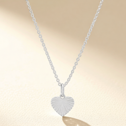 Heart pendant necklace with silver-tone chain and engraved heart charm
