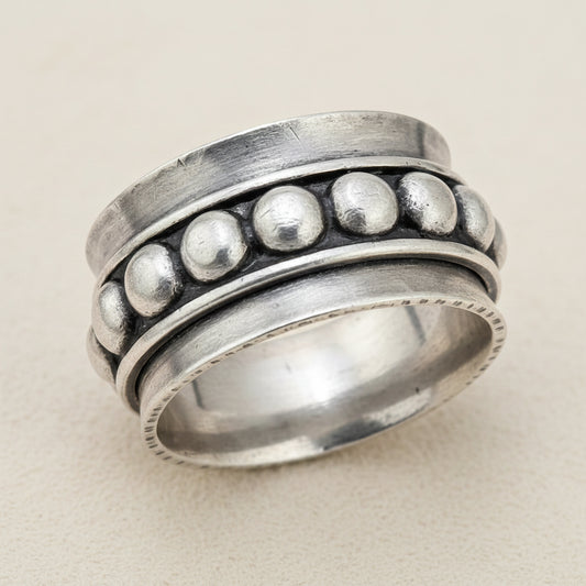 Silver spinner ring with raised round bead details on the outer band