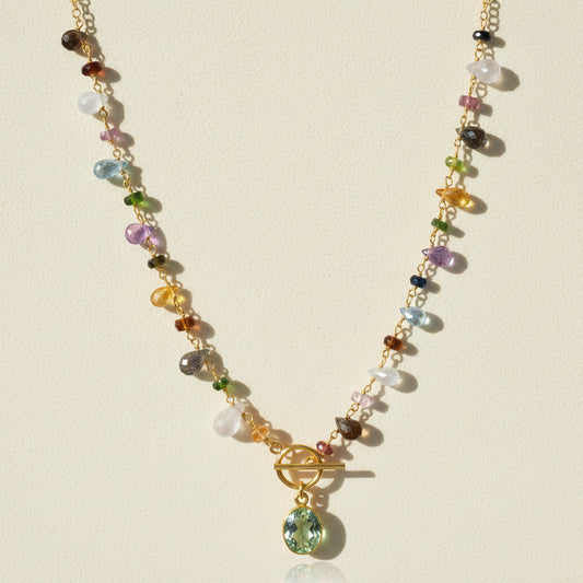 Gold-tone toggle necklace with multicolor beads and green oval pendant charm