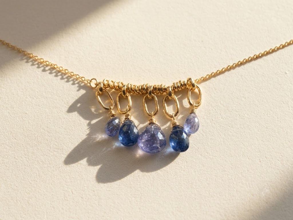 Gold chain necklace with clustered purple teardrop briolette gemstones