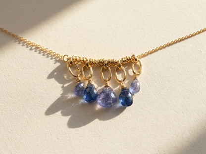 Gold chain necklace with clustered purple teardrop briolette gemstones