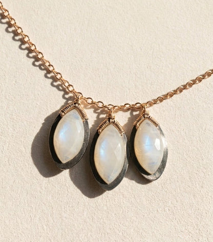 Gold tone moonstone oval drop necklace with three petal-like stones