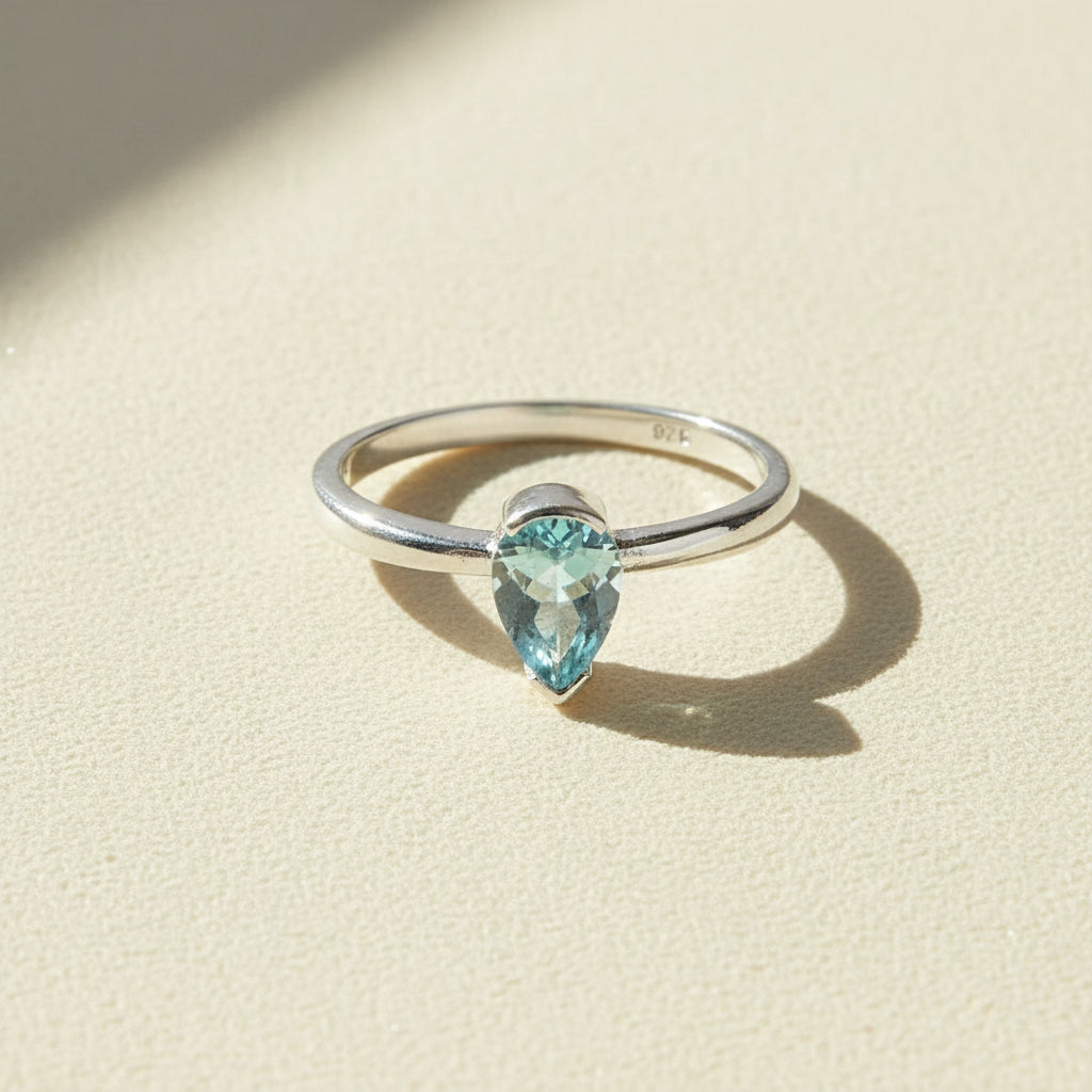Silver gemstone ring with marquise-cut light blue stone, slim band.