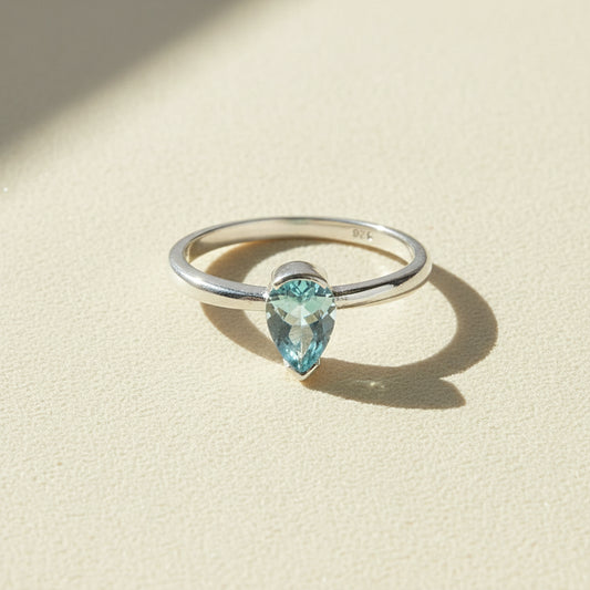 Silver gemstone ring with marquise-cut light blue stone, slim band.