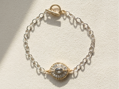 Silvertone chain bracelet with round medallion center in gold and dark details