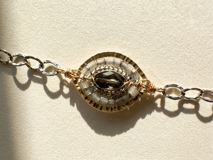 Medallion chain bracelet with round gold-and-silver centerpiece and linked clasp