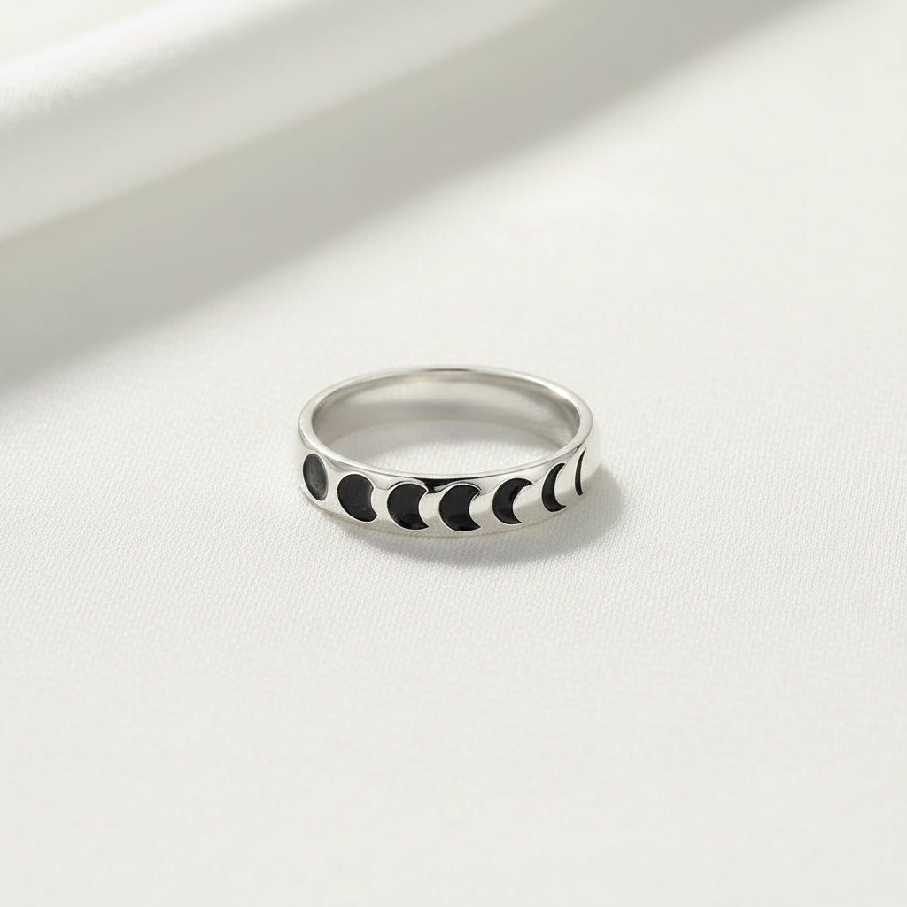 Silver ring with black moon phases on a white background