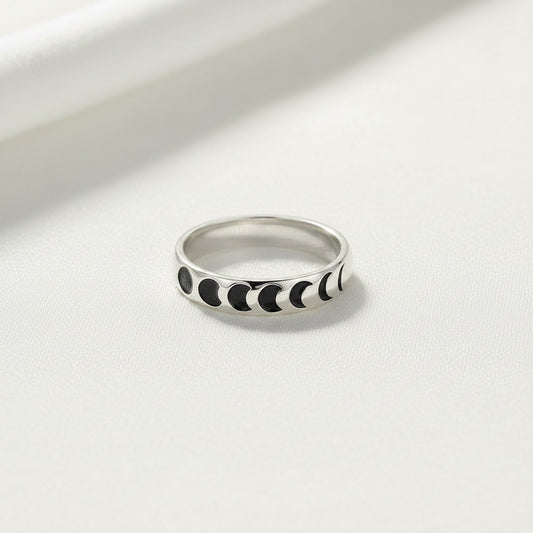 Silver ring with black moon phases on a white background