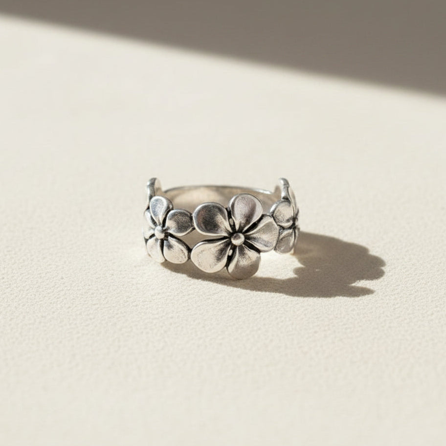 Silver ring with floral design on a white background