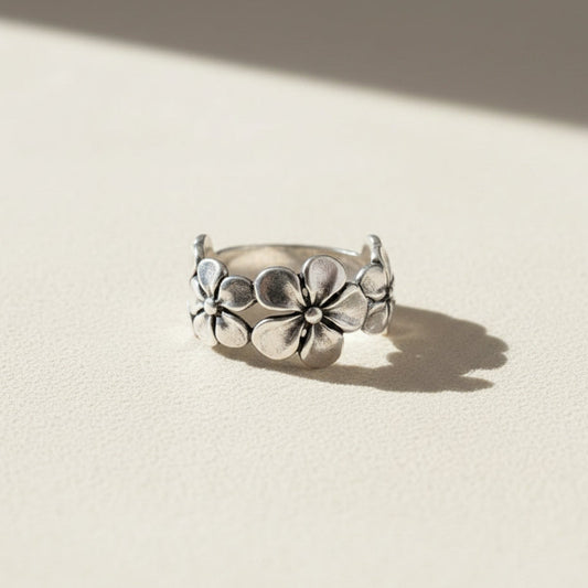 Silver ring with floral design on a white background