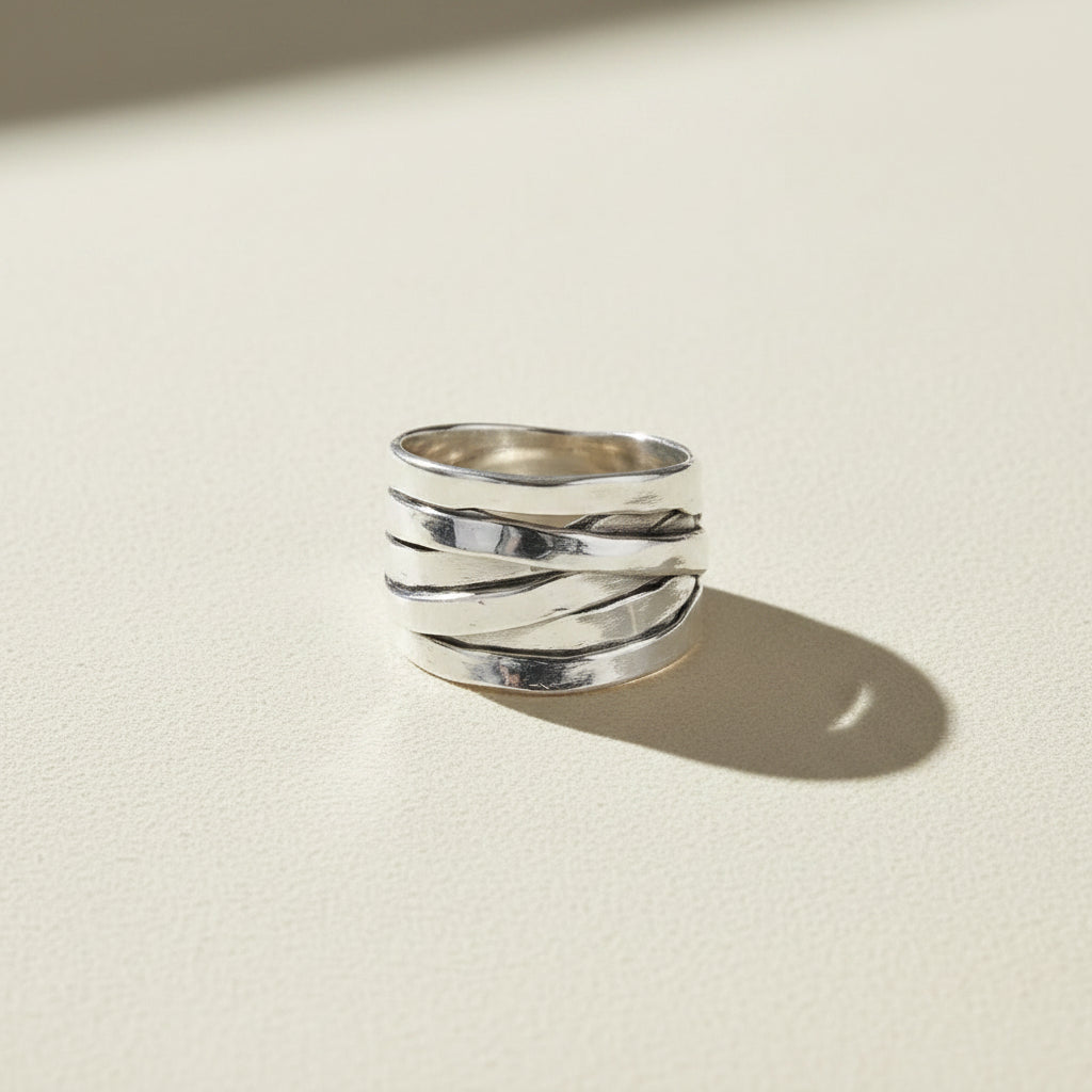 Silver ring with textured design on a white background