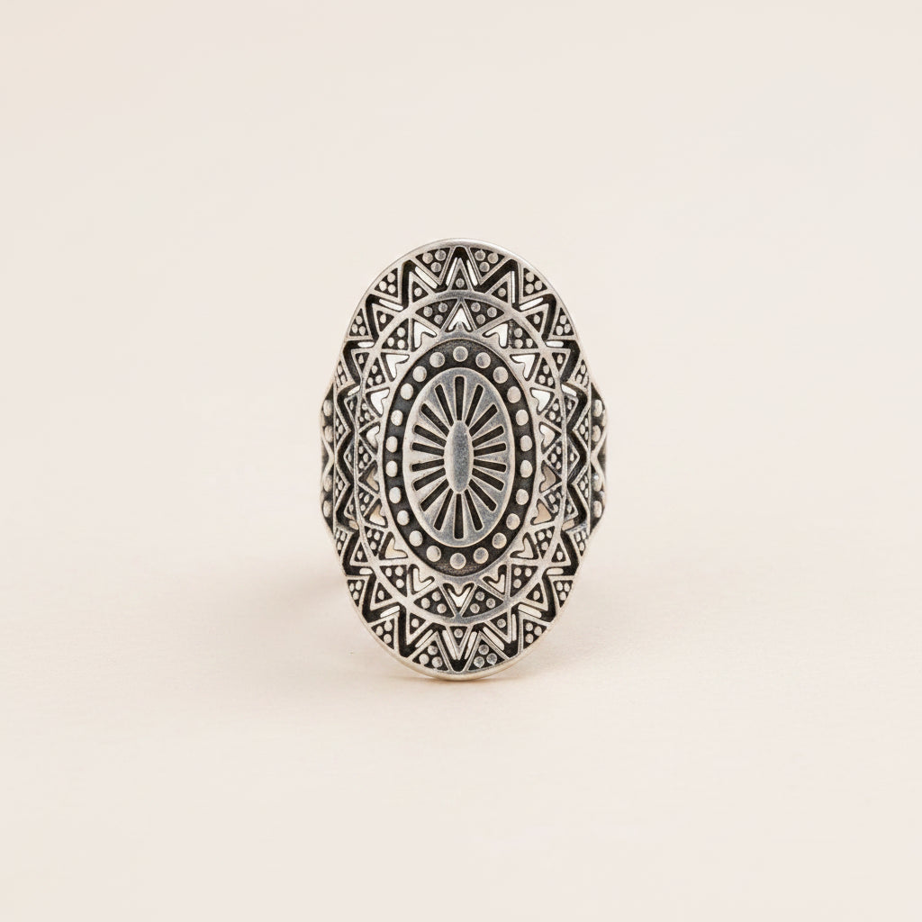 Silver ring with intricate geometric design on a white background