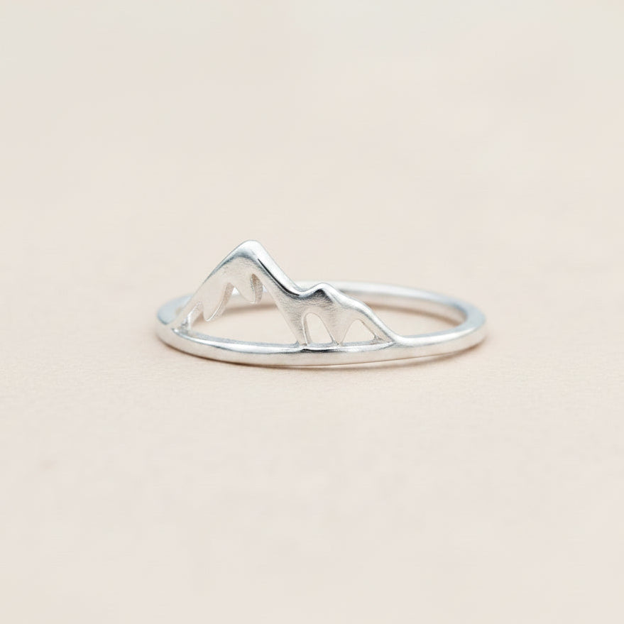 Silver ring with mountain design on a white background