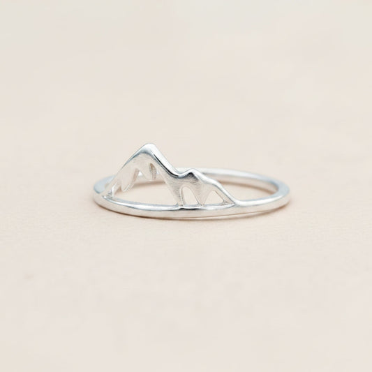 Silver ring with mountain design on a white background