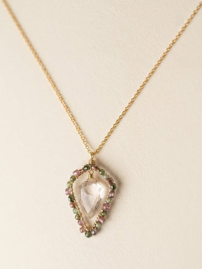 Gold-tone pendant necklace with pastel wrapped heart charm and stone border