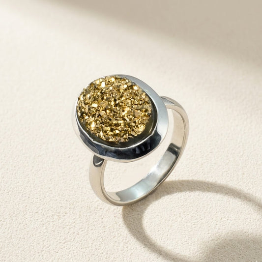 Oval druzy stone ring with gold glittery center and silver-tone bezel band