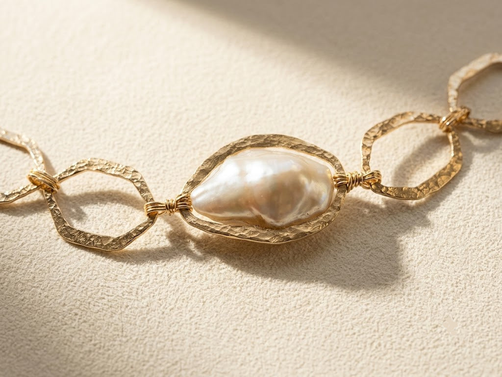 Gold-tone bracelet with hammered oval links and large white pearl center detail
