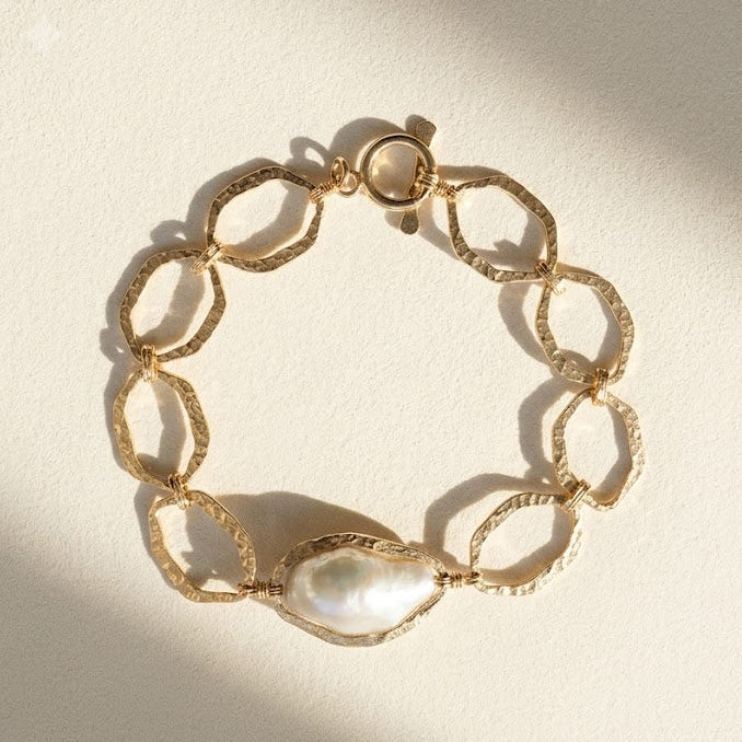 Gold-tone hammered link bracelet with white pearl centerpiece and oval links