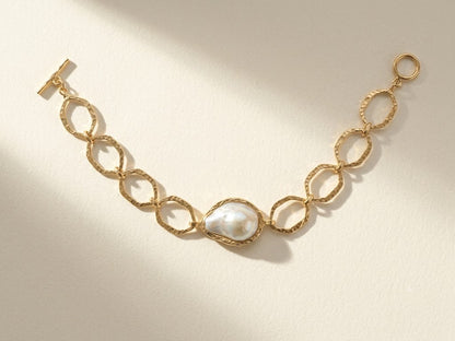 Gold-tone hammered link bracelet with white pearl center and hook clasp