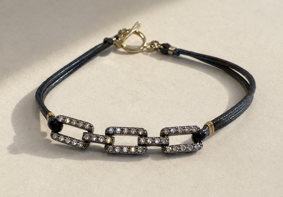 Pave diamond chain link bracelet with dark blue cord, black beads, and small heart clasp