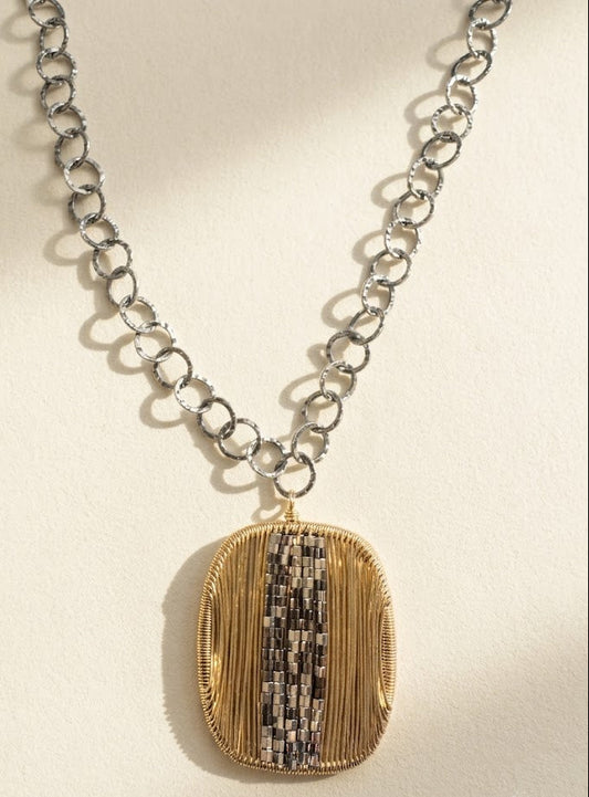 Two-tone oval pendant necklace with silver chain and gold-silver vertical stripe centerpiece