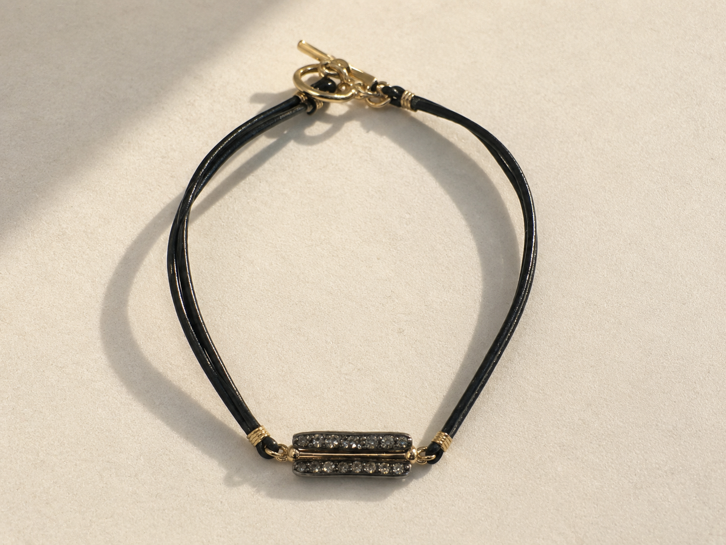 Pave diamond bar bracelet with black cord and gold clasp