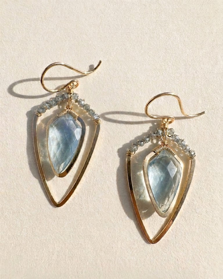 Gold-tone teardrop drop earrings with pale blue faceted crystal and fishhook backs